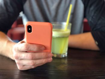 Close-up of man holding drink on table