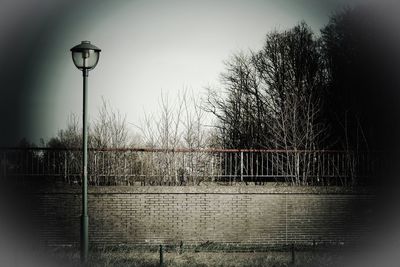 Street light by lake against sky