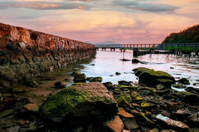 Bridge over sea against sky during sunset