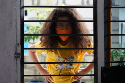 Portrait of woman standing by window