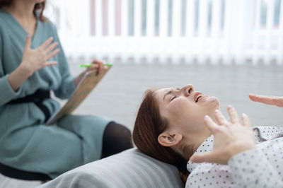 Friends using mobile phone while sitting at home