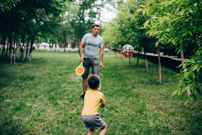 Full length of father and son on land