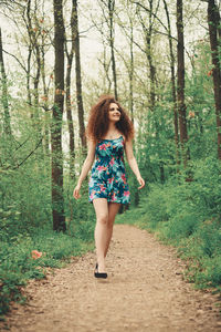 Full length portrait of young woman in forest