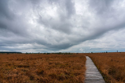 Footpath on field against sky