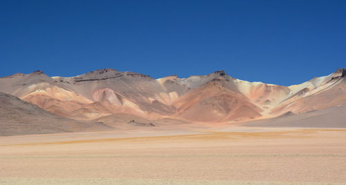 Scenic view of desert against blue sky