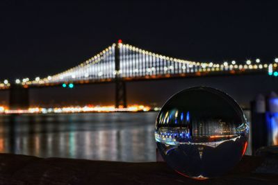 Illuminated bridge over river at night