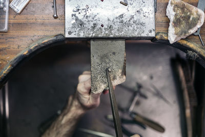 Cropped hand of worker working at workshop