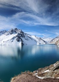 Scenic view of lake and snowcapped mountains against sky