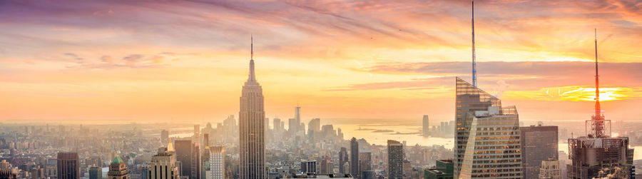 Modern buildings against cloudy sky during sunset