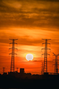 Low angle view of silhouette crane against sky during sunset