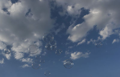 Low angle view of bubbles against sky