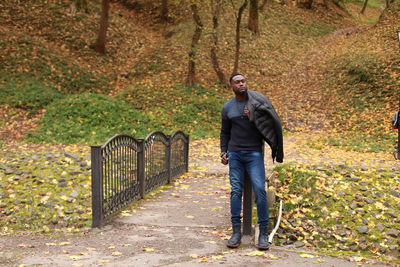 Portrait of man standing by tree during autumn