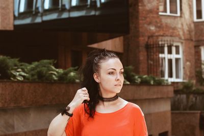 Beautiful young woman looking away in city