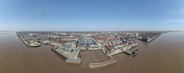 High angle view of cityscape by sea against sky