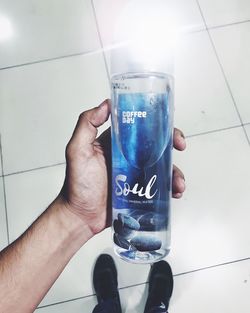 Close-up of hand holding blue glass