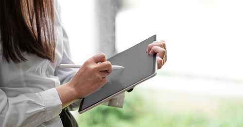 Midsection of woman holding smart phone
