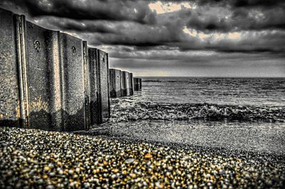 Scenic view of beach against cloudy sky