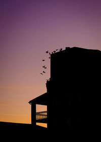 Silhouette of building against sky during sunset