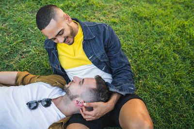 Cheerful friends sitting on grassland