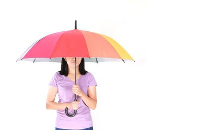 Woman holding umbrella against white background