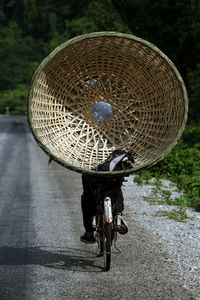 Person riding bicycle with basket on street