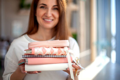 Portrait of smiling young woman holding camera