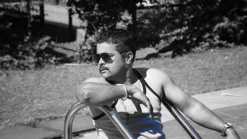 Young man sitting on sunglasses