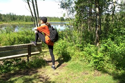 Side view of young man cycling on road