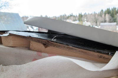 Close-up of snow on wood against sky