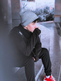 Side view of young man standing on street