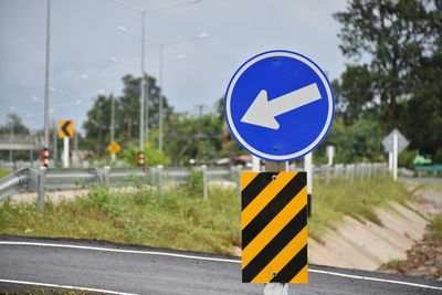 Road sign against blue sky