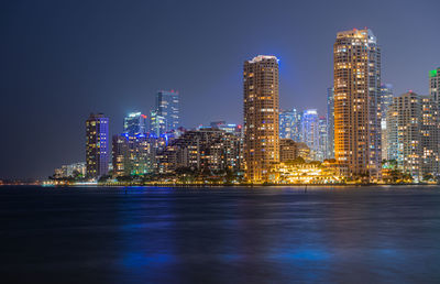 Illuminated buildings against sky at night