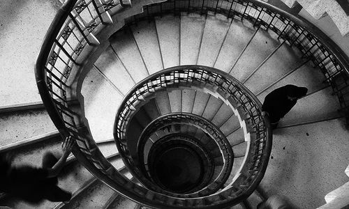 High angle view of people walking on spiral staircase in building