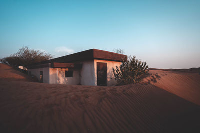 House on sand against clear sky