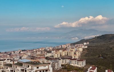 High angle view of townscape by sea against sky