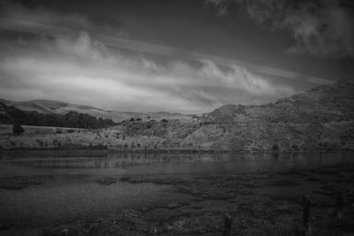 Scenic view of lake against cloudy sky