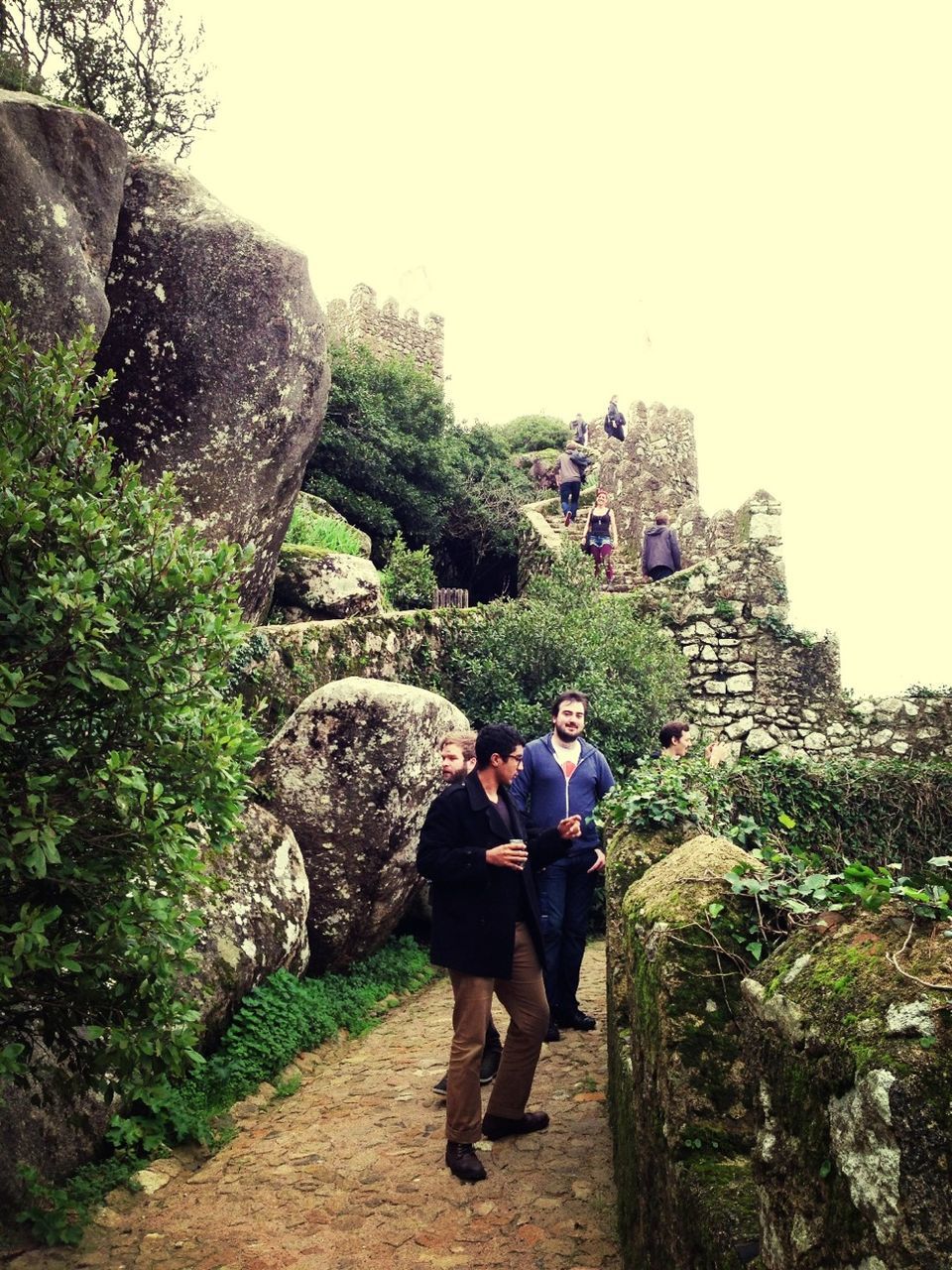 lifestyles, full length, men, leisure activity, rear view, person, built structure, walking, architecture, rock - object, clear sky, casual clothing, tourist, travel, building exterior, rock formation, history