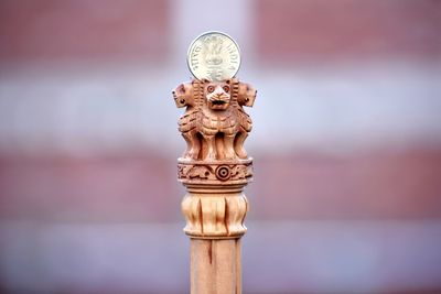 Close-up of coin on wooden lion statues