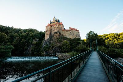 Bridge over river amidst buildings against clear sky