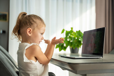 Side view of boy using mobile phone while sitting at home