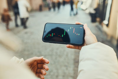 Person investing trading on stock cryptocurrency market using investing application on smartphone