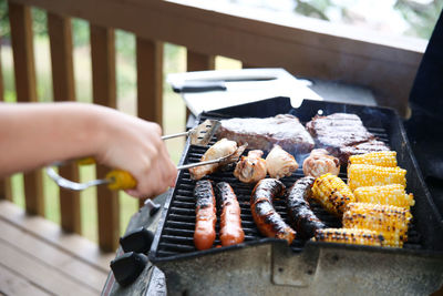 Person preparing food on barbecue grill