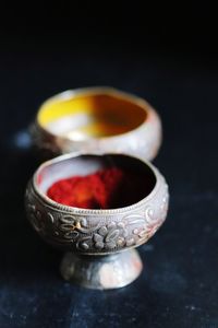 High angle view of turmeric and vermilion in silver containers