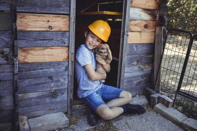 Full length of woman sitting on wood