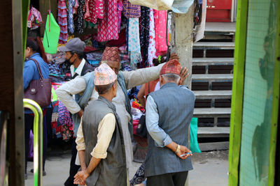 Rear view of people standing in market