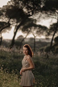 Portrait of young woman standing on field