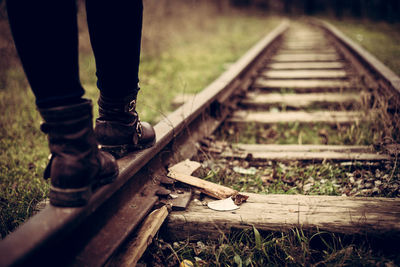 Low section of man walking on railroad track