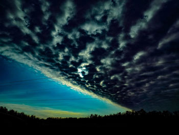 Scenic view of dramatic sky over silhouette landscape