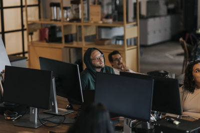 Multiracial male and female programmers discussing in startup company