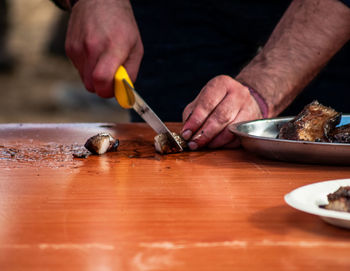 Midsection of man preparing food on table